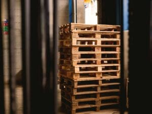 A stack of wooden pallets in an industrial setting.