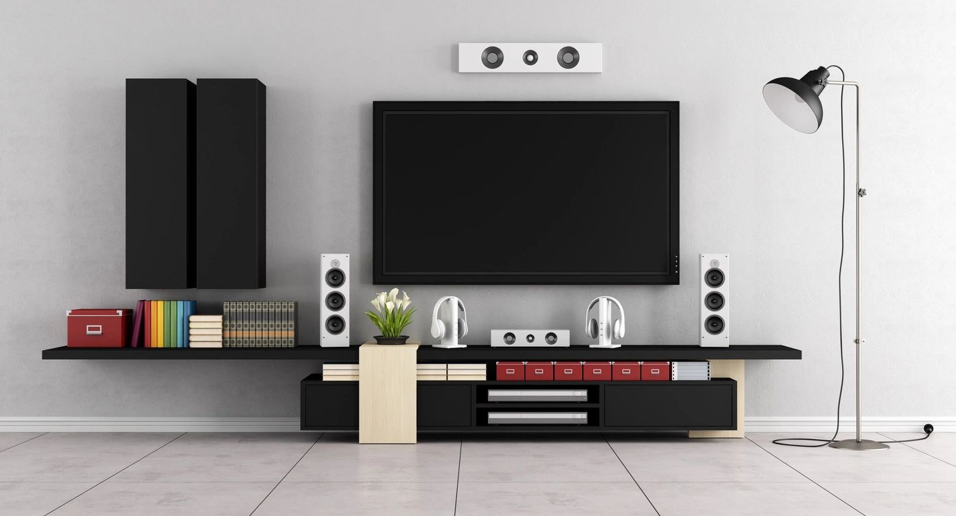 A living room with a tv and speakers on the wall